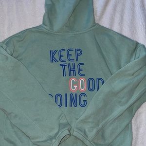 This is a blue hoodie with a little heart on the front and a saying on the back.